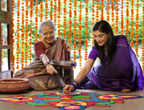 Mother and daughter making a rangoli 