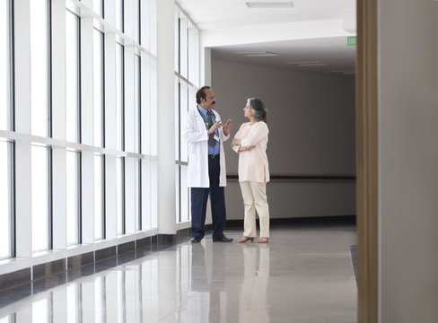Doctor discussing patient care in hospital corridor