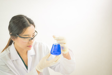 Young Asian scientist working in the lavatory with test tubes and other equipment to discover new drugs, products and methods of formulation