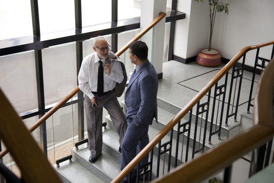 Two male executives talking on a staircase