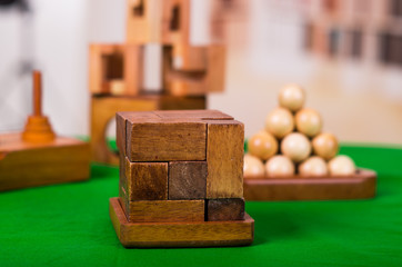 Wooden block brain teaser puzzle on green table in a blurred background