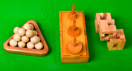 Assorted wooden brain teaser or wooden puzzles on green background