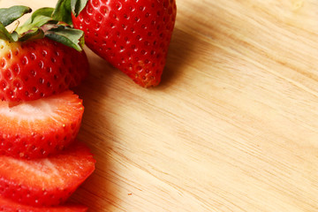 closed at group of sliced straberries on wooden tray