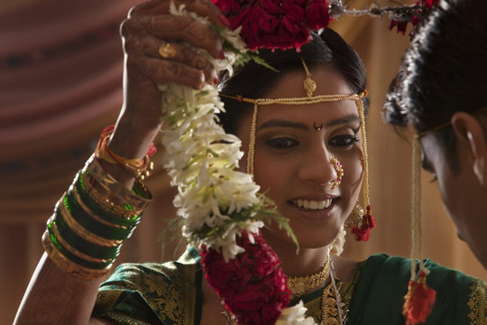 Maharashtrian bride and groom exchanging garlands in wedding 