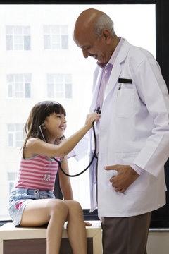 Girl checking a doctor's heartbeat 