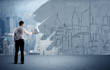 Elegant salesman repainting the city on wall