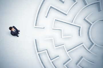 Business man looking at circular maze with nowhere to go