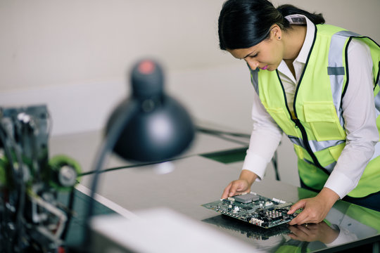 woman engineer checking a circuit board.