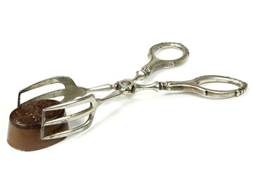 pastry tong  with Belgian chocolate praline isolated on white background