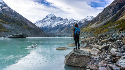 Girl standing in front of lake and mountains