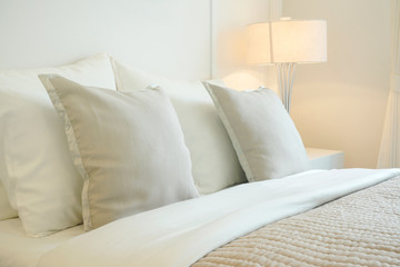 Fototapeta na wymiar Closeup pillow on bed in warm bedroom modern interior