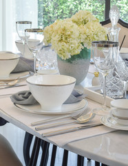 dining table and comfortable chairs in modern home with elegant table setting