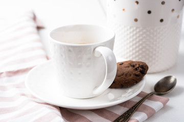 Cup of coffee and jar of chocolate cookies