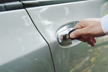 hand stabbing car key in handle hole and twist for open door