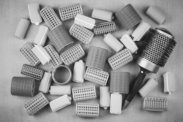 hair curlers of different sizes and comb top view closeup black and white photo