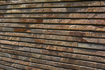 Stone wall texture background natural color. Decorative wall built of brown stone closeup