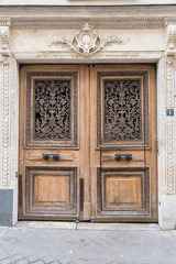 Fototapeta na wymiar Paris, old door with characters sculptured in the girder 