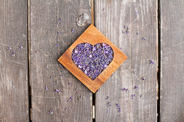 Lavender in wooden heart-shaped box on wooden background