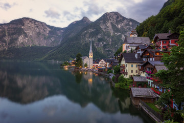 Fototapeta premium Scenic picture-postcard view of famous historic Hallstatt mountain village with Hallstattersee in the Austrian Alps in mystic twilight during blue hour at dawn in summer, Salzkammergut region, Austria