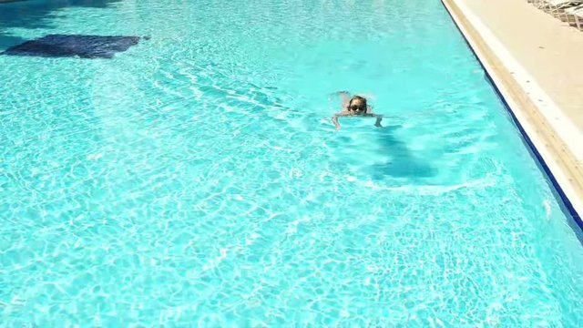 girl swims in pool, slow motion