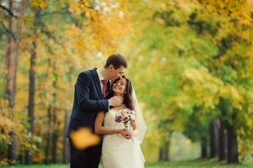 Beautiful wedding couple on a walk in autumn park