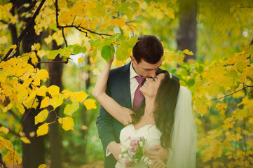 Beautiful wedding couple on a walk in autumn park