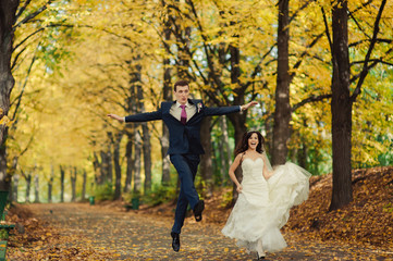 Beautiful wedding couple on a walk in autumn park