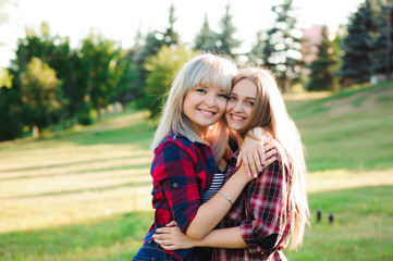 Two girls friends laughing and hugging. Hug and smile outdoor