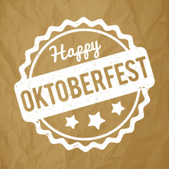 Oktoberfest rubber stamp white on a crumpled paper brown background.