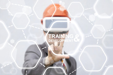 Training Development Augmented Reality Designing Building Industry Business Template concept. Man in VR glasses and hard hat presses training development button on a virtual graphical user interface.