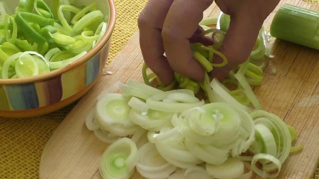 Chopped raw organic leek on a wooden cutting board
