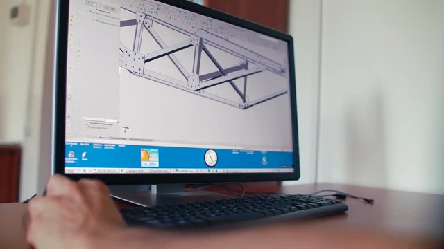 Rear view of engineer worker sitting and making 3d model on pc