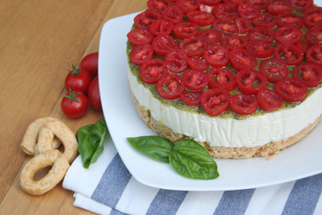 Cheesecake salata al formaggio e pomodori su piatto su tavolo di legno, Fuoco selettivo.