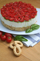 Cheesecake salata al formaggio e pomodori su piatto su tavolo di legno, Fuoco selettivo.