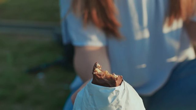 Young girl student eating chocolate bar