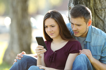 Worried couple seeing content in a smart phone