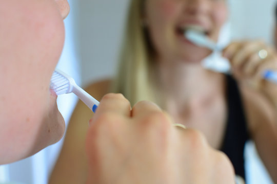 Blonde junge Frau putzt ihre Z&auml;hne