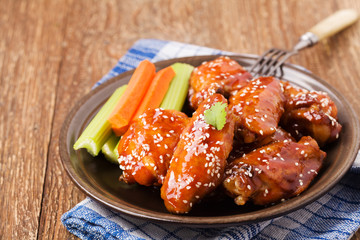 Baked chicken wings in honey sauce sprinkled with sesame seeds.