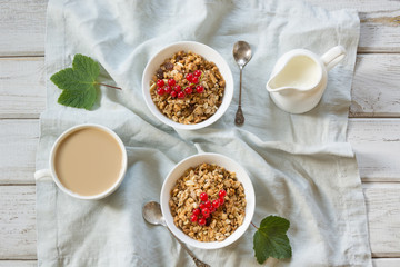 Summer healthy breakfast of granola, muesli with milk jug with red currant decor. Top view. Copy space.