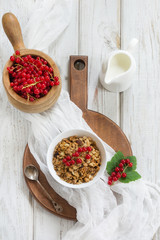 Summer healthy breakfast of granola, muesli with milk jug with red currant garnished. Top view. Copy space.