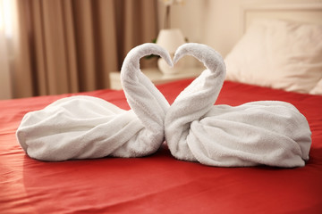 Two towel swans on bed in hotel room