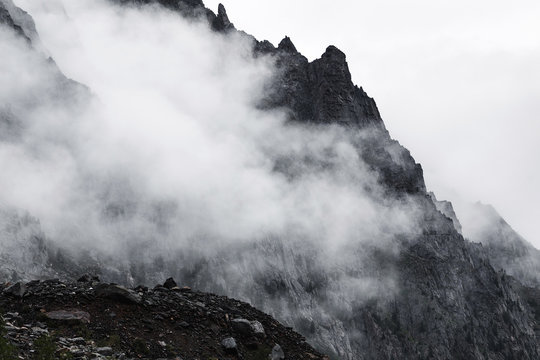 Fototapeta a view of rocky mountains with fog in black and white