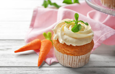 Delicious carrot muffin on wooden table, closeup