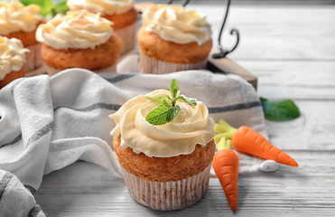 Composition with delicious carrot muffins on wooden table
