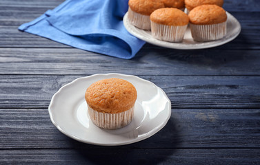 Plate with delicious carrot muffin on wooden table