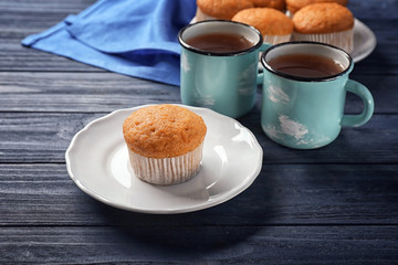 Plate with delicious carrot muffin on wooden table