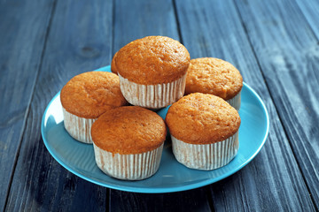 Plate with delicious carrot muffins on wooden table