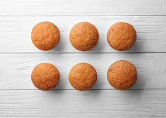 Delicious carrot muffins on wooden background