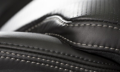 Black leather interior. Close up shot of stitches on a luxury car seat.