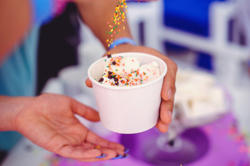 Ice cream in a hand in a cardboard cup